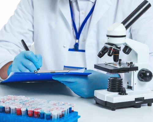 Scientist working with microscope on white background